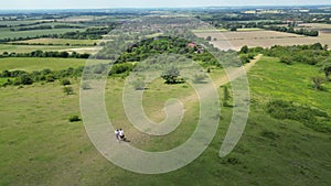 Drone Shot Of Mature Couple Walking With Pet Dog Through Beautiful English Countryside