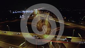 Drone shot on a night freeway with bridges and viaducts and car traffic.