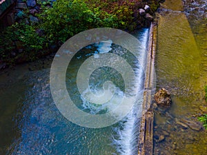 Drone shot out in nature of river, bridge and green trees. Copy