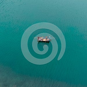 Drone shot of a small canoe at the sea in Lan Ha Bay, Vietnam.