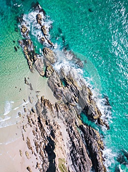 Beach aerial shot with aqua waves and cliffs