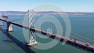 Drone shot of vehicles on San Francisco Bay Bridge over blue water