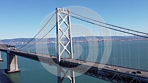 Drone shot of vehicles on San Francisco Bay Bridge over blue water