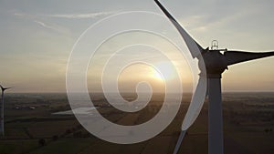Drone shot wind turbine farm during sunrise with fog over a rural landscape. Close-up Wind turbines sunrise. Windmills