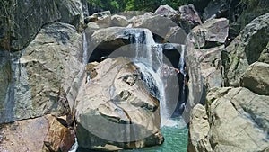 Drone Shows Cold Blue Lake on Foamy Waterfall Foot