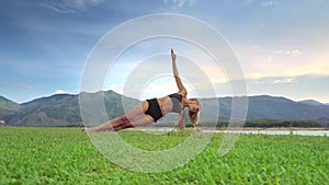 Drone Side View Girl Holds Yoga Position against Green Hills