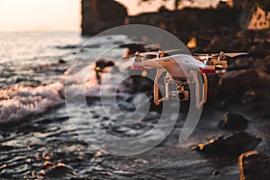 The drone in the sunset sky. ocean wave mountains Close up of quadrocopter outdoors. concept for film maker wedding videography