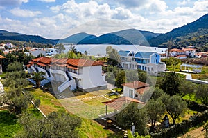 Drone top view from above to blue lake landscape with forest hills background for rural countryside village. Aerial panorama