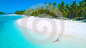 DRONE: Tourist girl in bikini sunbathing on the beautiful exotic island beach.