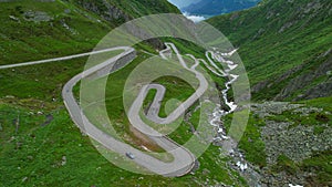DRONE: Tourists on fun road trip across Switzerland drive along Gotthardpass.