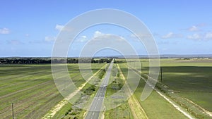 Drone, travel and a car on a highway in the countryside for freedom or adventure on a green landscape. Earth, sky and