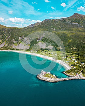 Drone vertical shot of a beachline and mountain with cloudy sky in the background in northern Norway