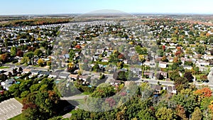 Drone video flying backward over Riviere-Nord public park in St-Eustache at the beginning of Autumn revealing the properties in