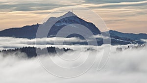 Drone video in winter with fog in a valley in front of the mountains