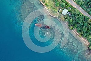Drone view of abandoned broken sunken old ship that ran aground. Tropical coast of Sanma, Vanuatu photo