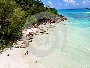 Drone view from above at Anse Lazio beach Praslin Island Seychelles, couple men and woman on beach