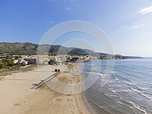 drone view of the beach of El Cargador in Alcober with the Sierra de Irta Natural Park in the background, aerial view