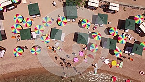 Drone view of bright rainbow sun umbrellas on Queens Beach, near Villa Milocer