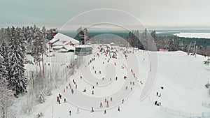 Drone view on cable way in ski resort. Ski lift elevator transporting skiers and snowboarders on snowy winter slope at