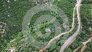 Drone view captures mountain, country road in green canyon. Panoramic footage of mountain, country road winding through