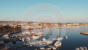 Drone view of city harbor marina bay with ships sailing from sea and boats and yachts parked floating near pier