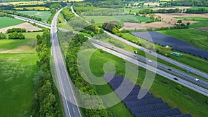 Drone view of a highway in Germany with a lot of traffic and many green fields around it