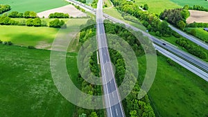 Drone view of a highway in Germany with a lot of traffic and many green fields around it