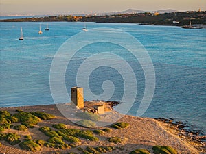 Drone view of Isola Piana by La Pelosa Beach, Sardinia. Well-preserved ruins of Torre di Punta Imbarcatogio, a defensive and