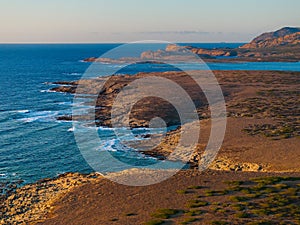 Drone view of Isola Piana by La Pelosa Beach, Sardinia. Well-preserved ruins of Torre di Punta Imbarcatogio, a defensive and