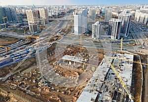 Drone view of a large construction site. Tower cranes in action on fog background. Housing renovation concept.