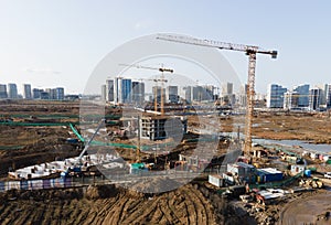 Drone view of a large construction site. Tower cranes in action on fog background. Housing renovation concept. Crane during