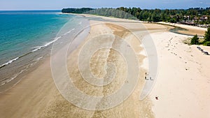 Drone view of a large, deserted tropical sandy beach and shallow, warm ocean (Memories Beach, Khao Lak, Thailand