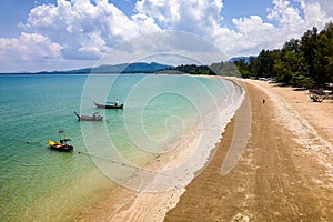 Drone view of longtail boats moored off a tropical sandy beach in Khao Lak, Thailand