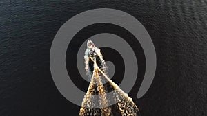 Drone view of luxury boat cruising in high speed in blue sea