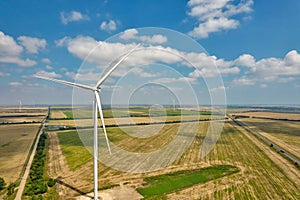 Drone view over wind farm turbine closeup against blue sky