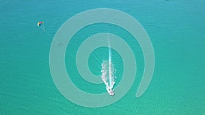 Drone view parasail flying over blue sea. Parasailing aerial view. Summer activity and extreme entertainment while