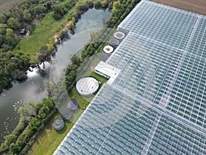 Drone view of a part of a huge commercial glass house growing young plants.