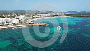 Drone view of people enjoying parasailing in Sa Coma beach in Mallorca, Spain on a summer day