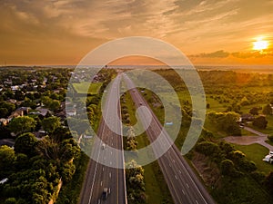 Drone view of the Port Hope streets surrounded by buildings and nature during a colorful sunset photo