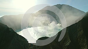 Drone view of silhouette shadow active volcano crater, caldera with acid lake