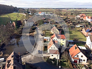 Drone view of a small town with one- and two-story private houses and the road leading to them