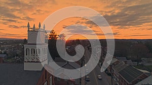 Drone View of a Small Town and a Steeple at Sunrise as it gets Ready to Break the Horizon