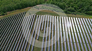 Drone view of a solar power station next to a forest during summer. Renewable energy meets nature in action