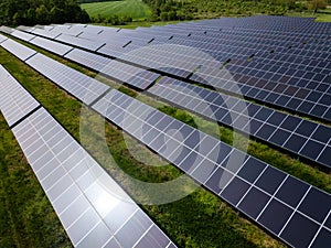 drone view of a solar power station next to a forest during summer. Renewable energy meets nature in action