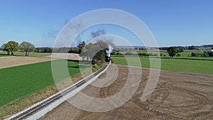 Drone View of a Steam Passenger Train Rounding a Curve Blowing Smoke and Steam