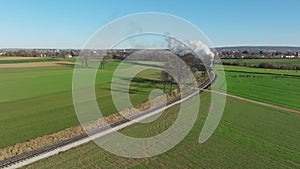 Drone View of a Steam Passenger Train Rounding a Curve Blowing Smoke and Steam