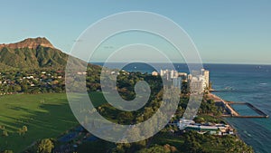 A drone view at sunset of Waikiki Beach and Diamond Head Crater, a famous tourist destination in Honolulu, Oahu, Hawaii