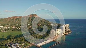 A drone view at sunset of Waikiki Beach and Diamond Head Crater, a famous tourist destination in Honolulu, Oahu, Hawaii