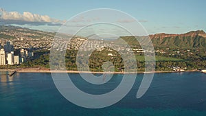 A drone view at sunset of Waikiki Beach and Diamond Head Crater, a famous tourist destination in Honolulu, Oahu, Hawaii