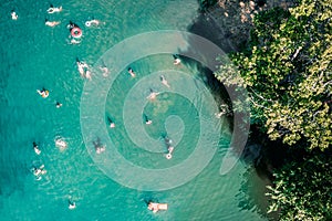 Drone view of swimming people in blue lake or pond